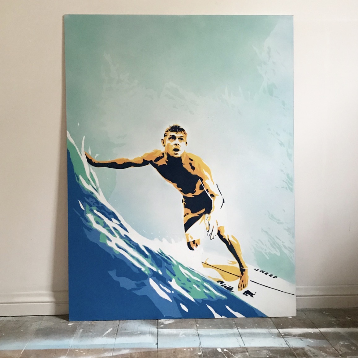 Stencil painting of a surfer riding a wave