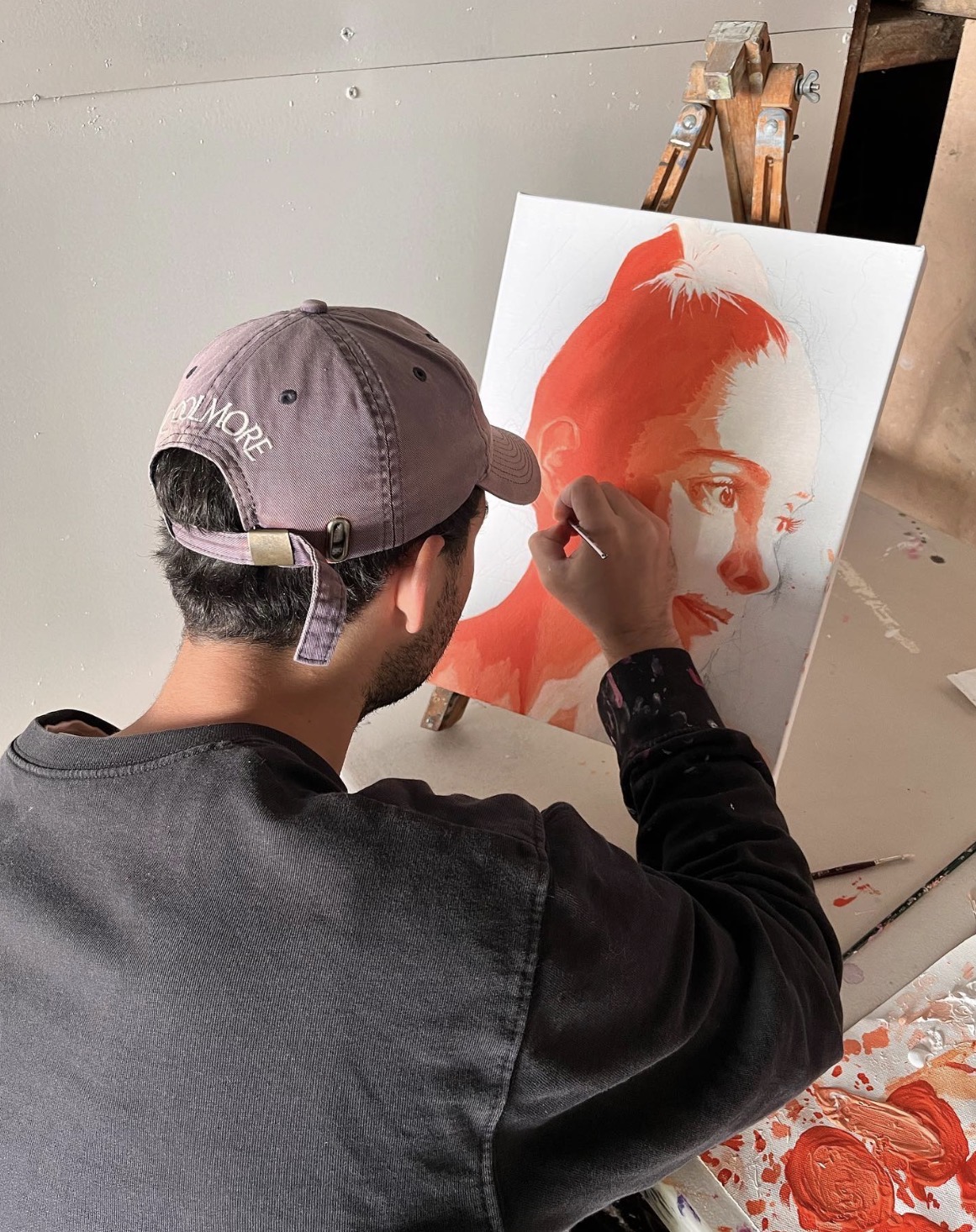 WILBUR painting an orange portrait on canvas