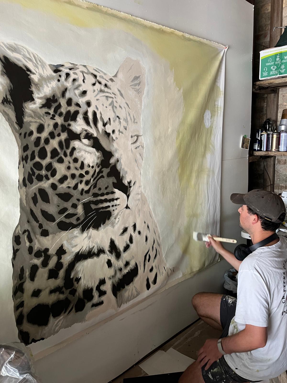 WILBUR painting a large leopard artwork in the studio
